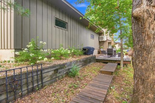 Deck and walkway blend naturally into the wooded landscape surrounding the home.