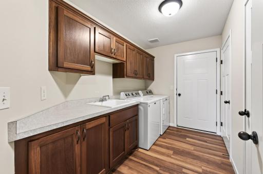 Spacious laundry room with built-in cabinetry and utility sink.