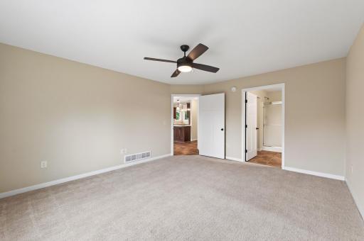 Spacious primary suit with ceiling fan.