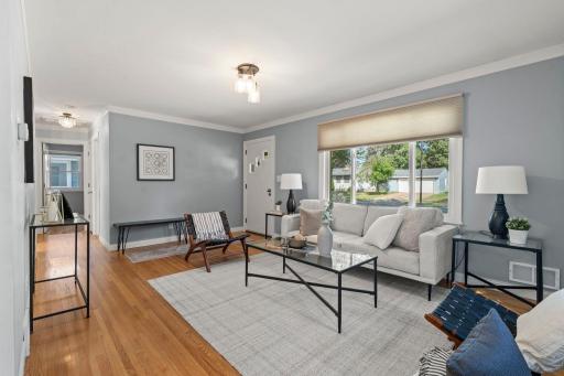 The spacious living room welcomes you with a large front-facing picture window that fills the space with natural light and highlights the original wood floors.