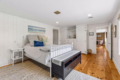 Lower level 4th bedroom with built-in cabinetry and adjacent to a 3/4 bathroom.