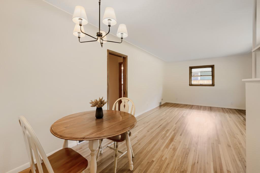 View of living room and dining space. Freshly painted and cute new light fixture!