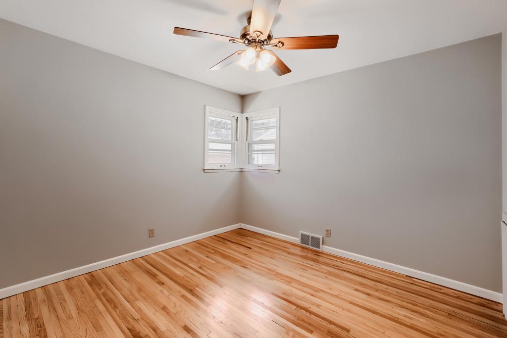 3rd bedroom with ceiling fan and wood floors