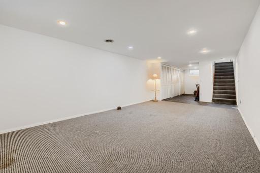 Lower level family room with recessed lights and work shop or home work area in back