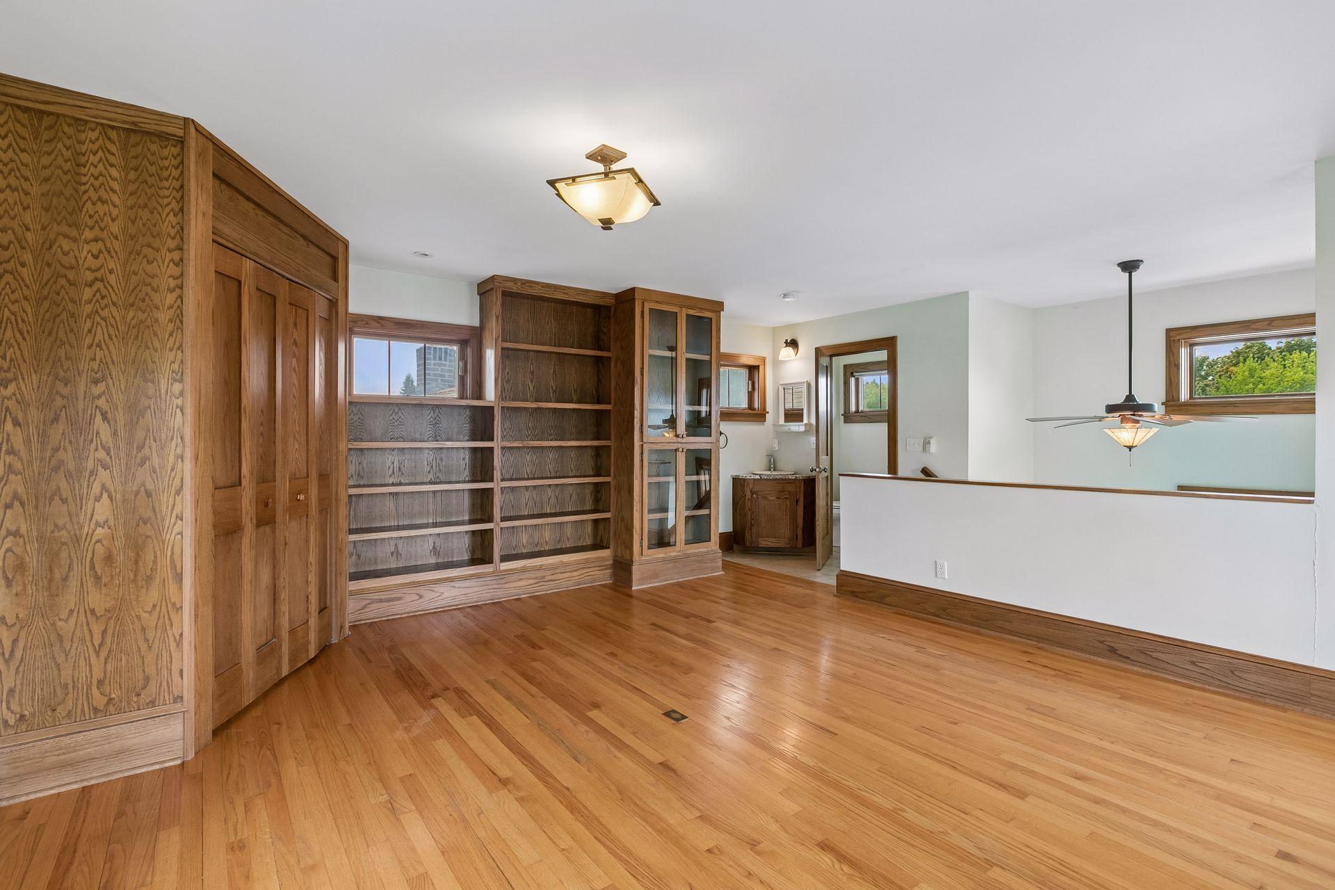 Custom built-in bookcases and cabinetry with corner wall-in closet. Open staircase allows for tons of natural light.