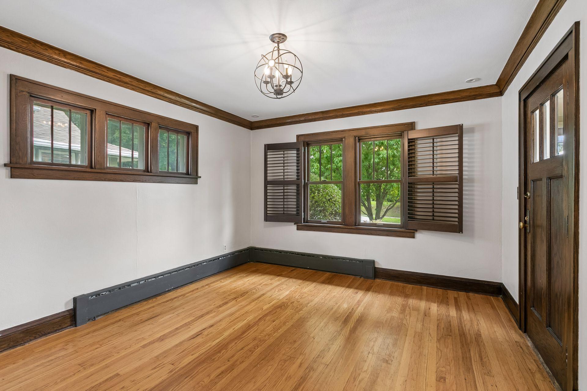 Bright and airy living room with gorgeous architectural details - showcasing the original dark woodwork.