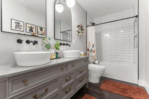 Large guest bath with dual sinks & tile tub surround conveniently located near the 3 additional bedrooms