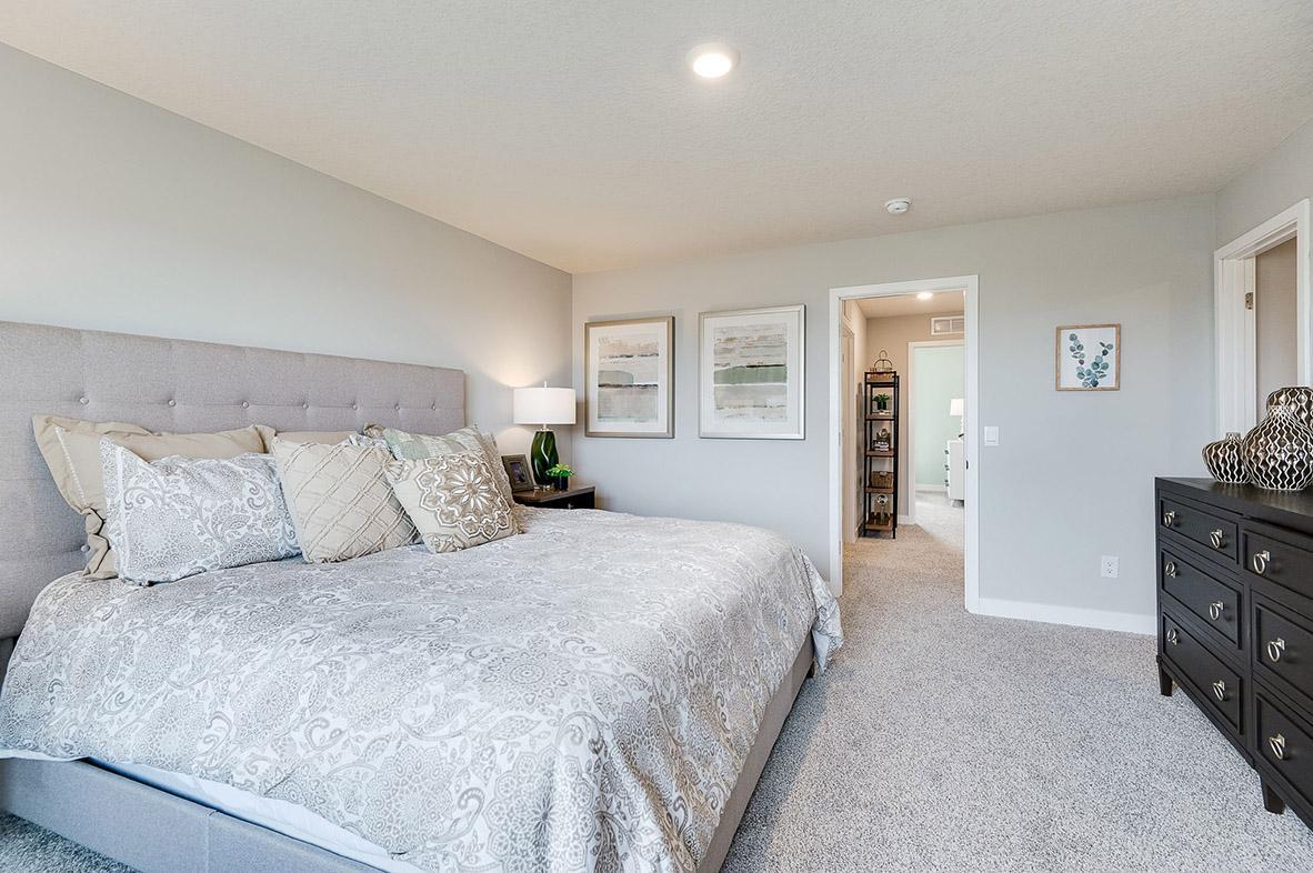 A second view of the Primary Suite. Shown here with a King-sized bed, the room is overly spacious and offers the perfect setting to start and finish each day in! Photo of model home, color & options may vary.