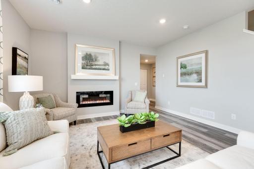 The home's family room is nicely sized & the fireplace provides warmth & ambiance. Photo of model home, color & options may vary.