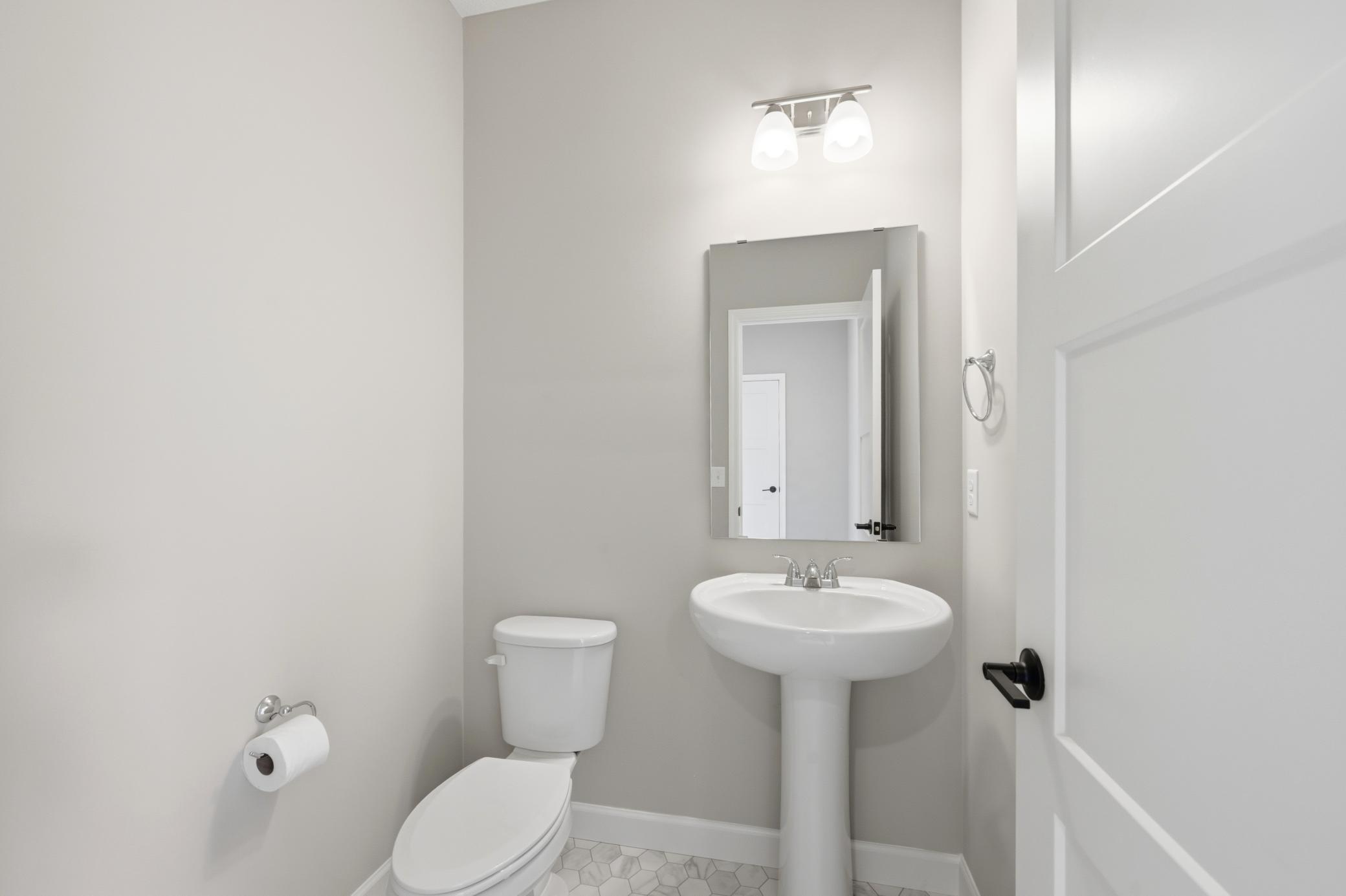 Main floor powder room - photos of a completed home of the same floorplan. Colors and selections may differ.