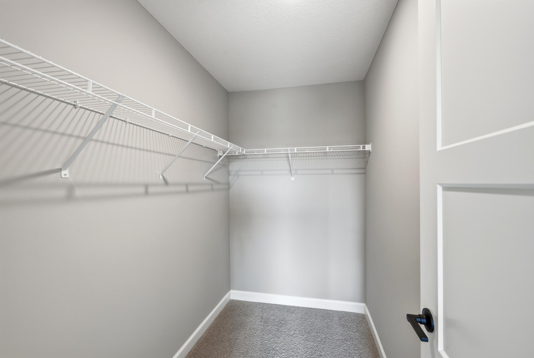 Primary suite walk-in closet - photos of a completed home of the same floorplan. Colors and selections may differ.