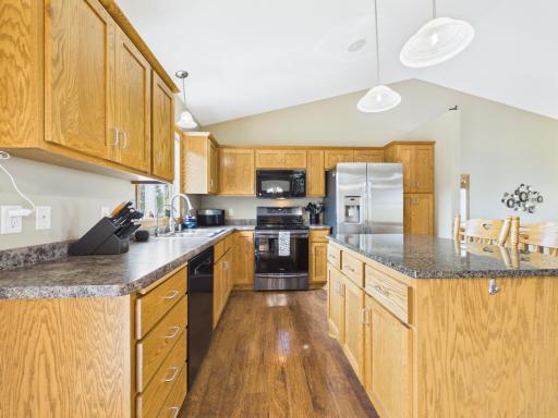 Kitchen features granite center island, newer stove, and new refrigerator