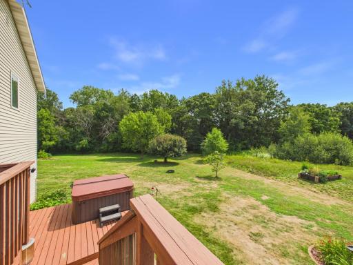 Backyard features a hot tub, two-tiered deck, & no backyard neighbors