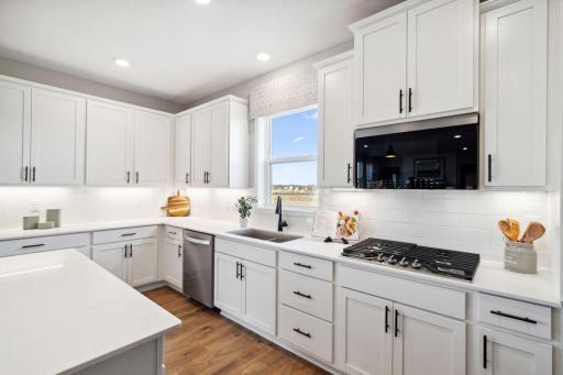The center of the home, the kitchen! Large island, quartz countertops, subway tile backsplash, gas cooktop, double ovens, and huge walk-in pantry!
