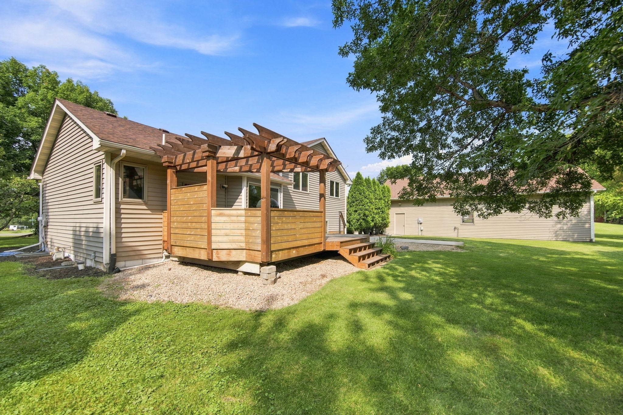 Backyard showcasing the beautiful pergola and side of the detached garage!