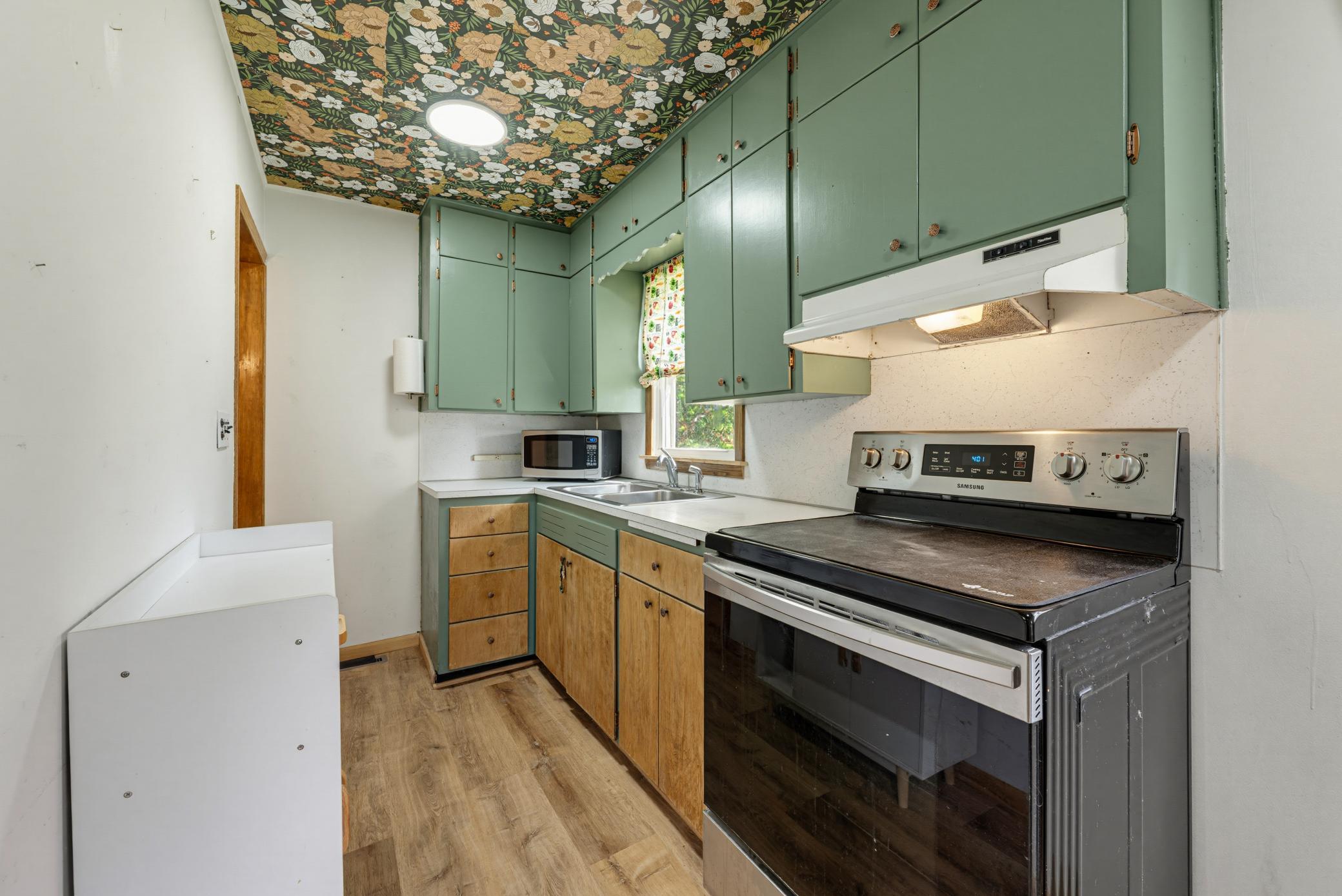 The kitchen features a suite of S.S. appliances, including an electric range with a glass top, a refrigerator, and a microwave.