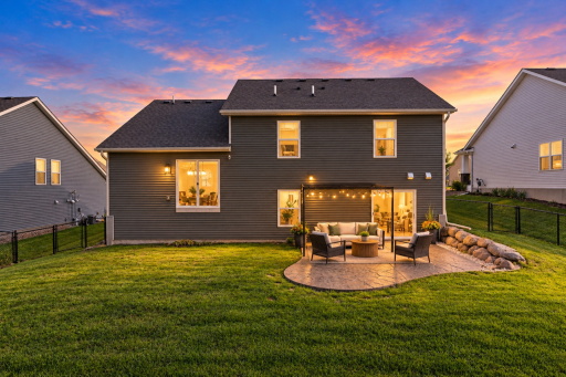 Walkout lower level opens to a custom stamped concrete patio and fully fenced yard.