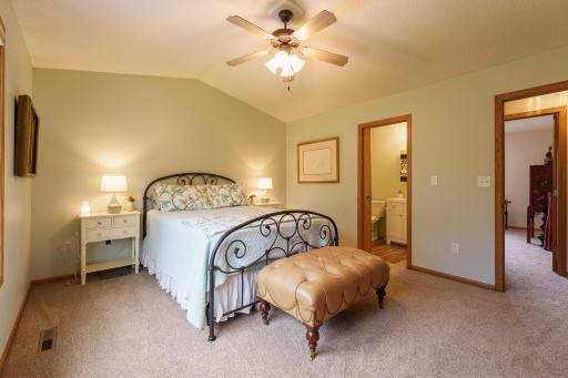 Primary bedroom has a vaulted ceiling, ceiling fan, and walkthrough bathroom.