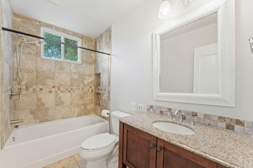 Main Floor Full Bathroom with limestone and granite tile and heated bathroom floor!
