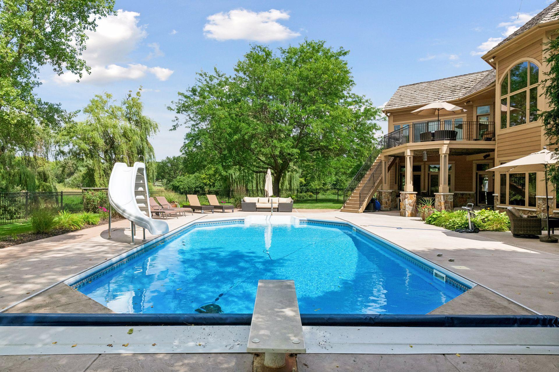 The pool has a diving board and a slide, perfect for enjoying with family and friends.
