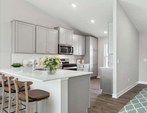 Charming kitchen situated in the front of the home with sunny kitchen window. Quartz countertops, tile backsplash and stainless appliances.