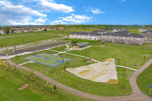 A vibrant community space at Timber Creek featuring a basketball court, skate park, covered picnic area, and open green spaces.