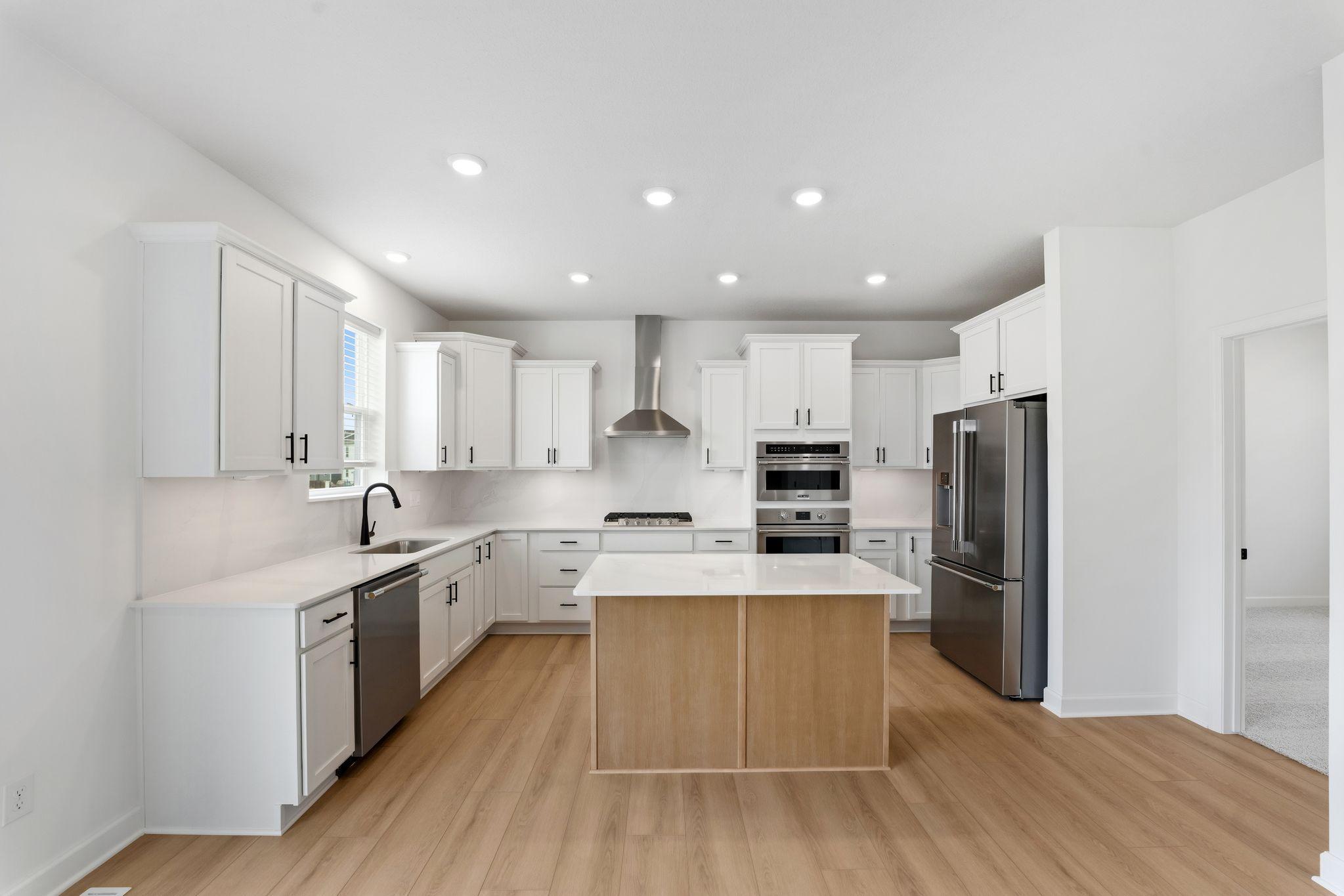 This modern kitchen features a set of brand-new stainless steel appliances, abundant cabinet space and a convenient center island to add seating and counter room.