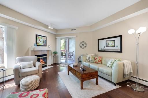 Gorgeous hardwood flooring and gas fireplace. The living room gives you access to the covered balcony.