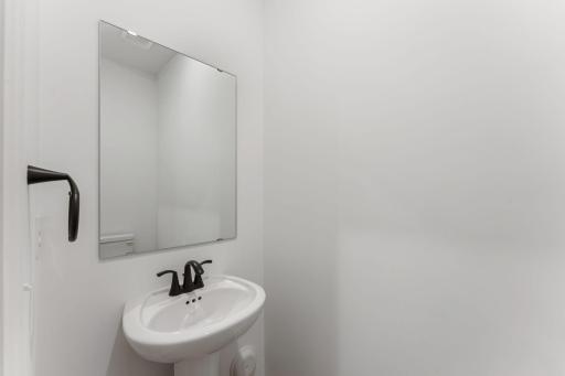 (Photo of a similar home, actual finishes may vary) In a discreet location on the first floor is a convenient powder room to accommodate the needs of the whole household and visiting guests.
