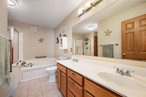 The walkthrough bath has ceramic ploors, a dual sink vanity, a large soaking tub and a separate shower!