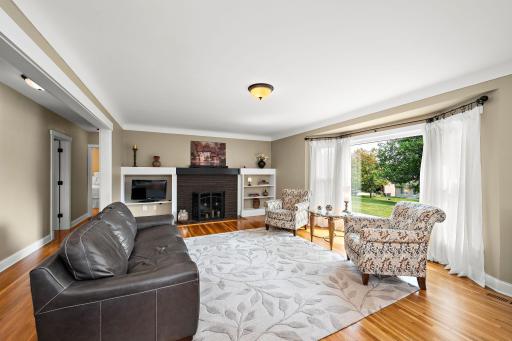 Beautiful living room with coved and smooth ceiling, brick fireplace, and built-in shelves!