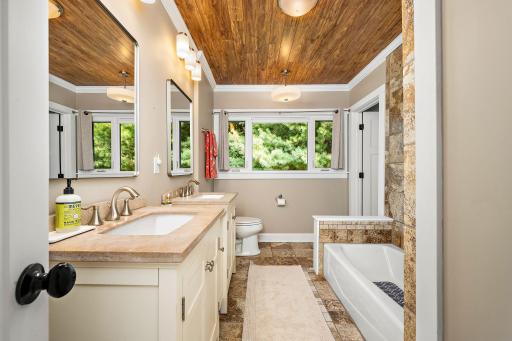 The main floor bath is beautiful with the tiled surfaces, the warm ceiling, and the double sink vanity!