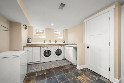 The laundry offers modern washer and dryer, counter and cabinet space, and a sink!