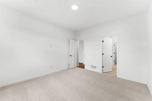The bedroom features wall-to-wall plush carpeting