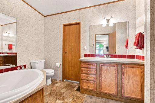Primary En-Suite Bathroom with soaking tub and step in shower. Door has the option to lead to the laundry room.