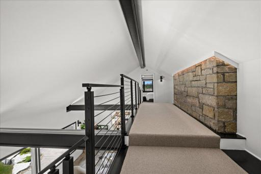A distinctive upper-level walkway separates two additional bedrooms, creating a sense of privacy and retreat. A refreshed ¾ bath and partial Lake Superior views make this level equally suited to family or guests.