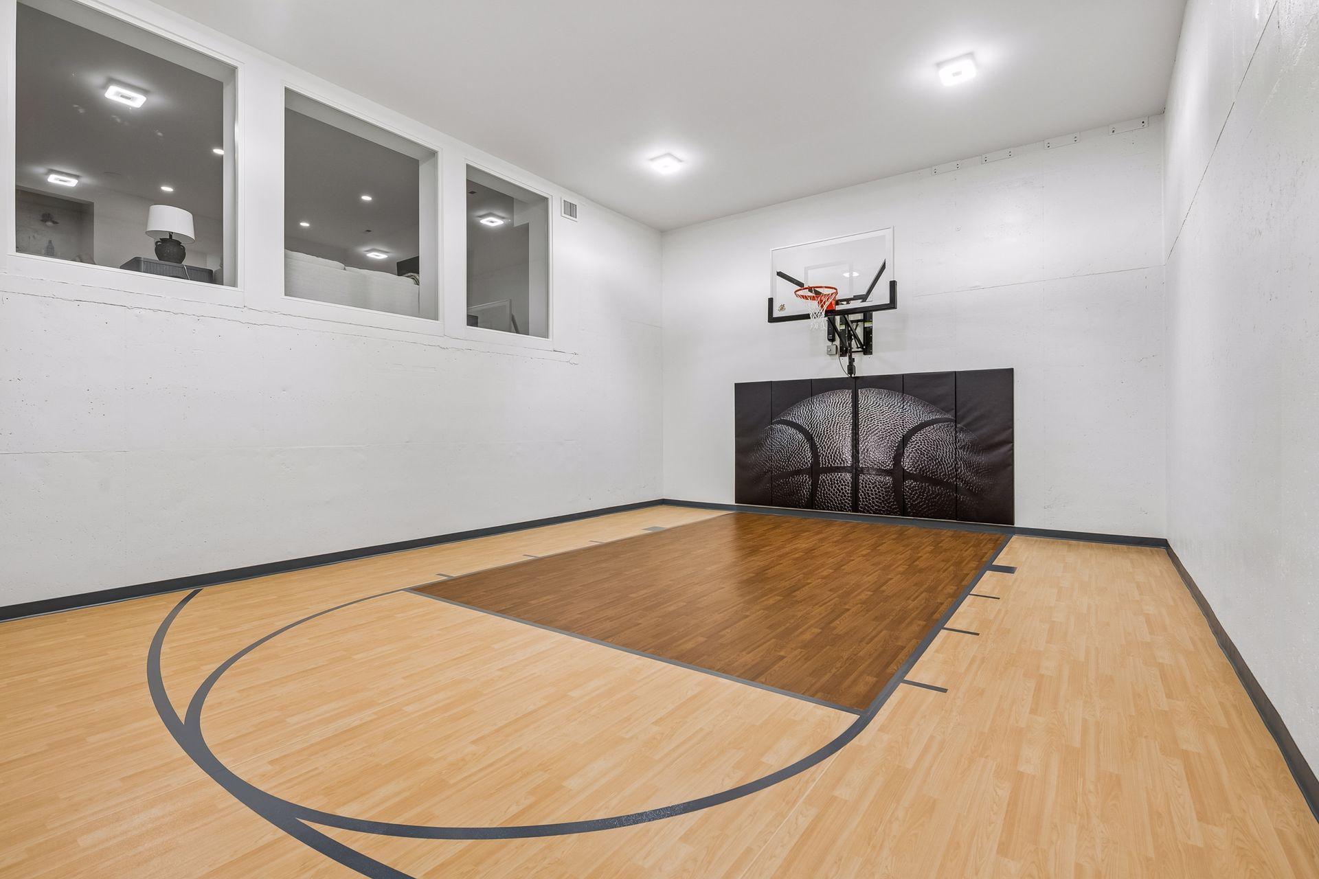 Sports court featuring electronic remote control basketball hoop (photo of completed home at 5252 Lochloy)