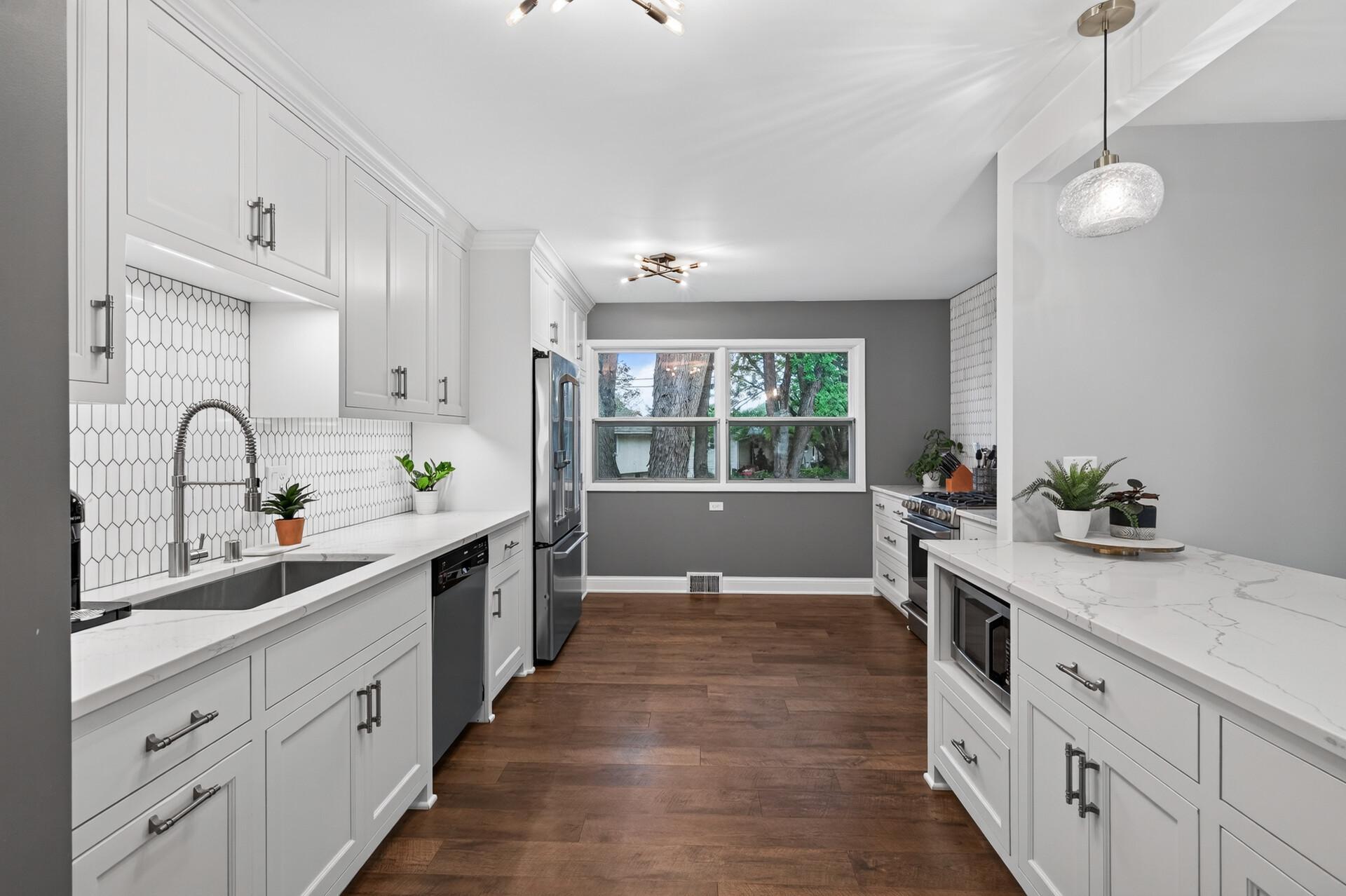 Completely remodeled kitchen with tiled backsplash, stone countertops, and new cabinetry