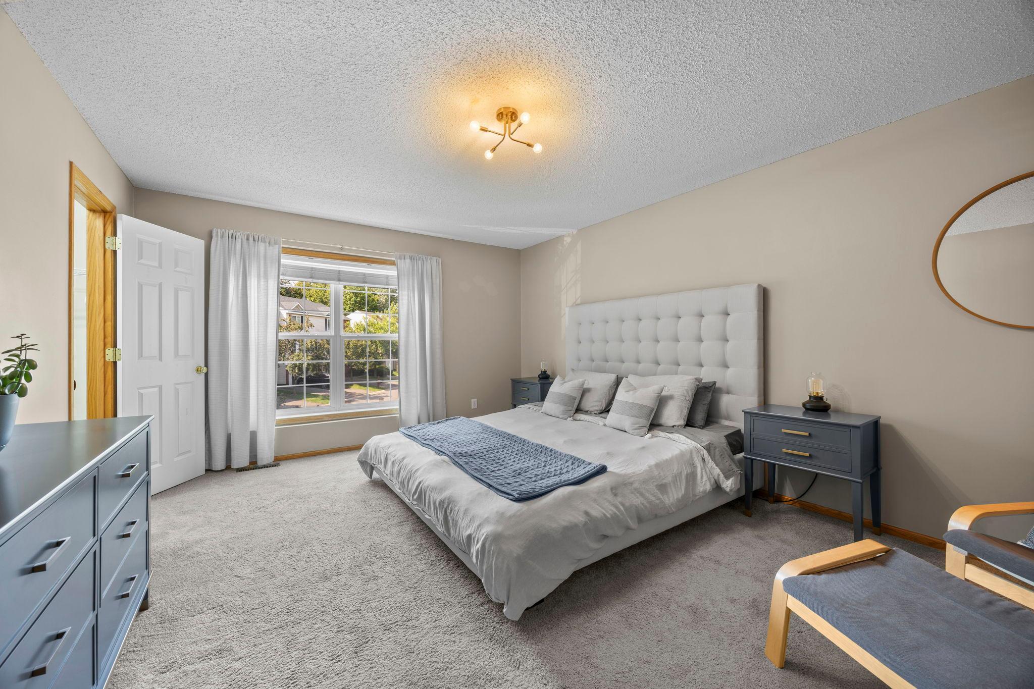 Upstairs, the spacious primary bedroom features abundant natural light and a walk-in closet.