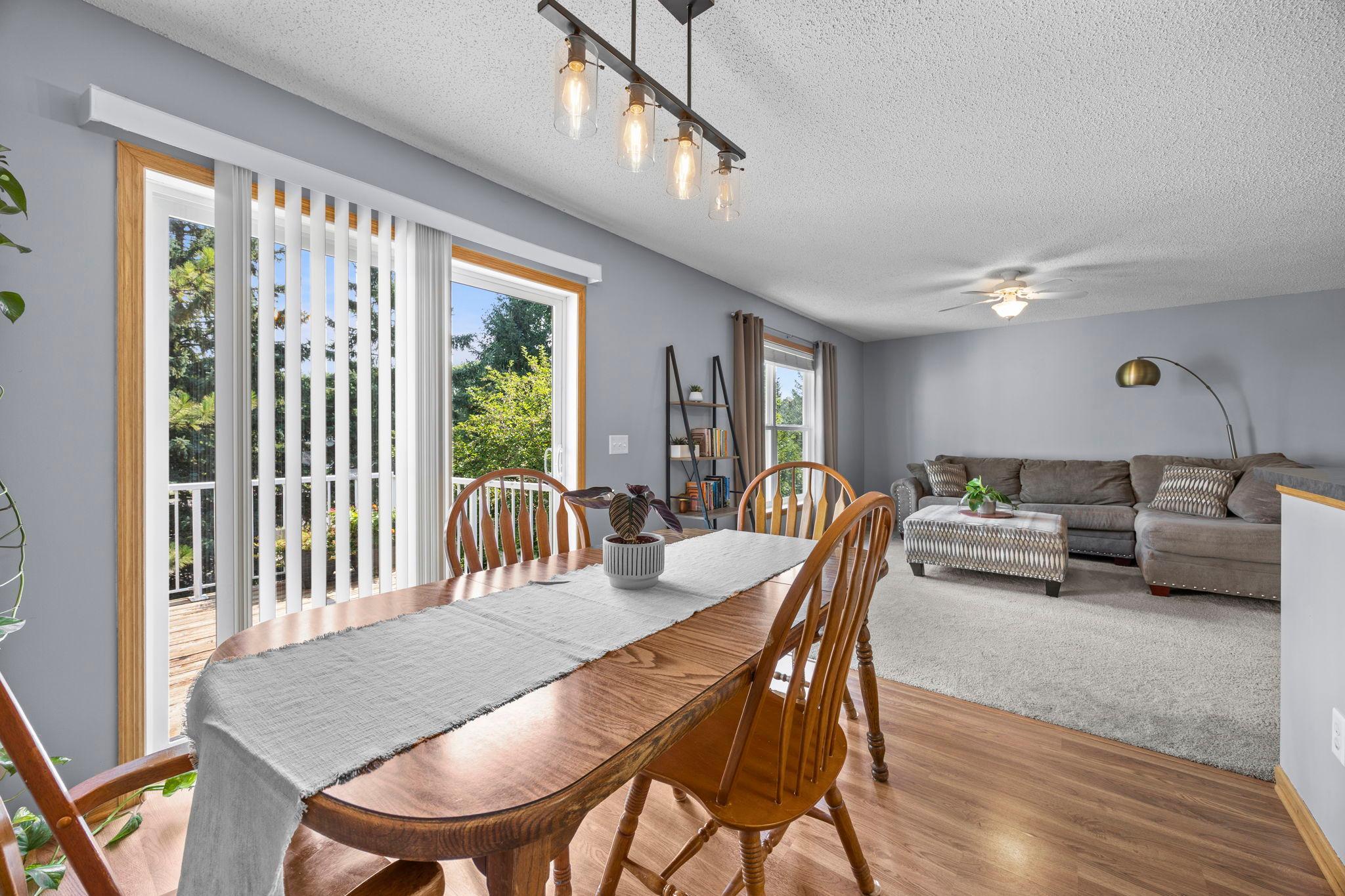 Just beyond, the dining area brings in timeless hardwood floors and statement lighting.