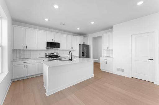 Blending style and functionality effortlessly, the kitchen features ample cabinet space, durable quartz countertops and a set of all-new stainless steel appliances to simplify mealtimes.