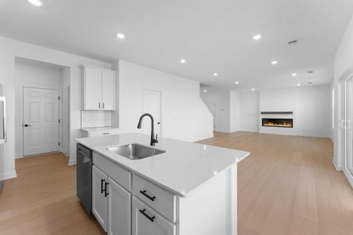 The center island has an open line of sight to the dining and living areas of the home