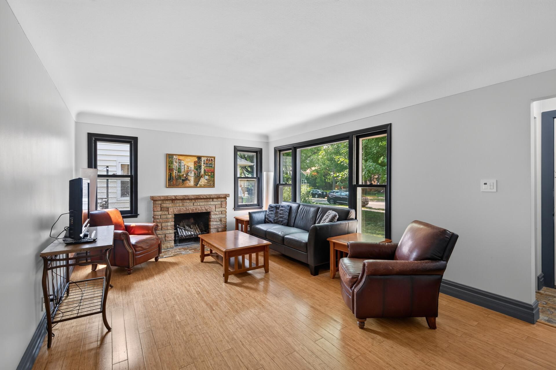 Living room with wood burning fireplace and oversized windows