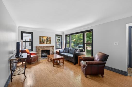 Living room with wood burning fireplace and oversized windows