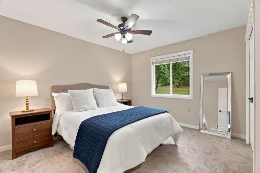 Comfortable primary bedroom with soft neutral finishes, generous natural light, and peaceful backyard views.