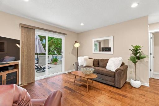 Open upper level living room with hardwood floors, recessed lighting, and sliding door access to the deck.