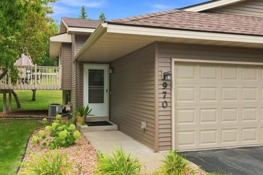 Welcoming split-entry twin home with 2 car garage, mature trees, and a quiet neighborhood setting.