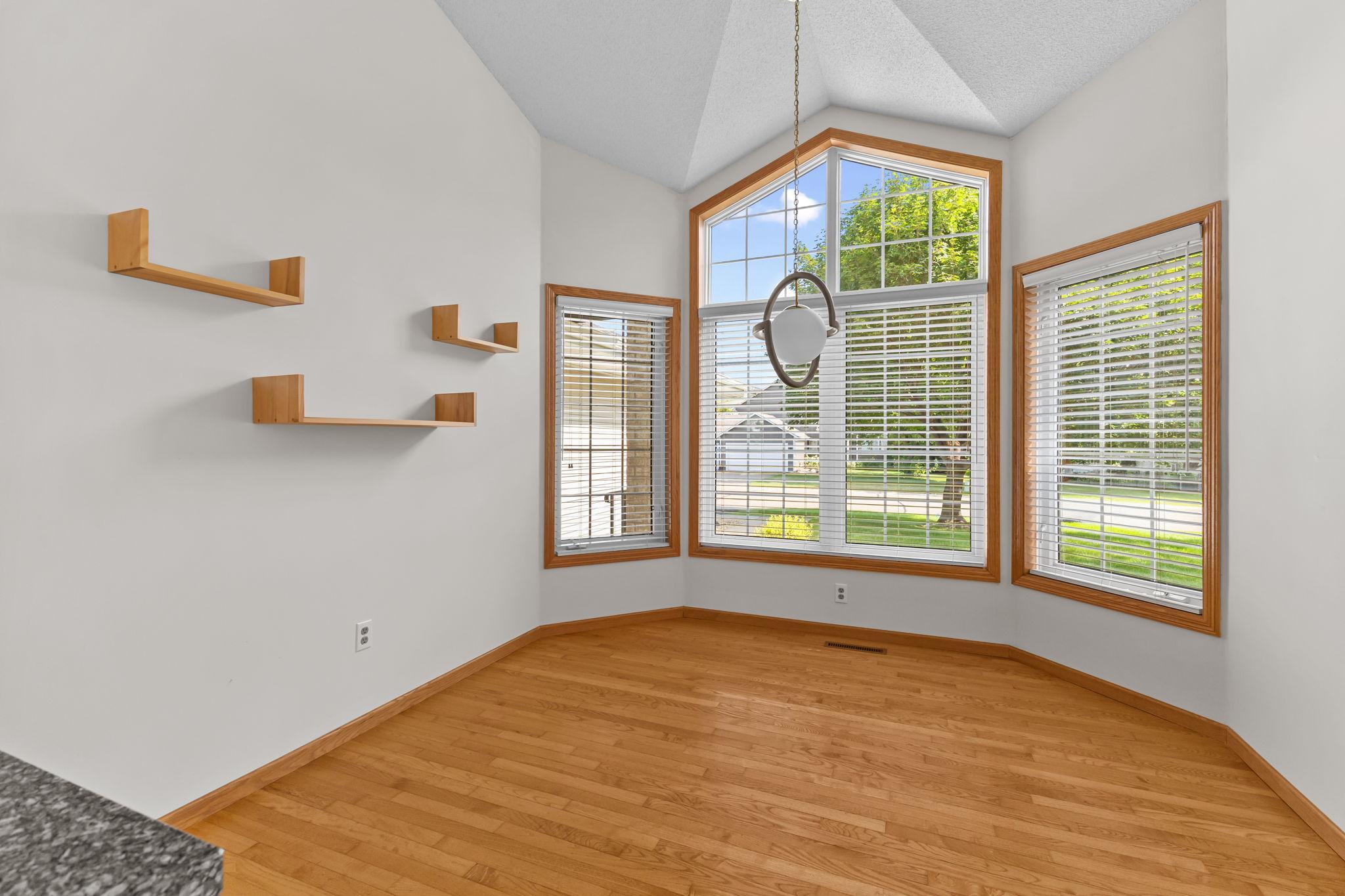 Sun-filled dining area with vaulted ceiling and expansive windows.