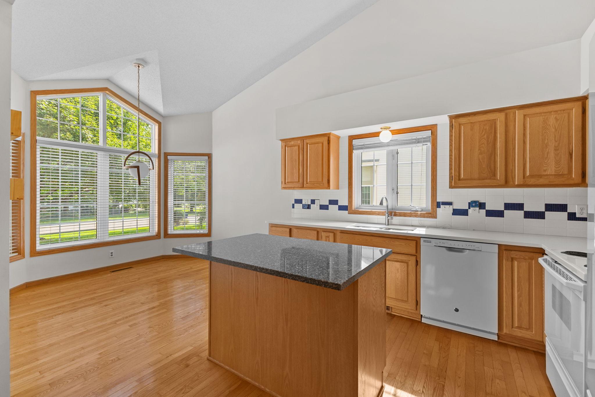 Kitchen opens to a bright dining area surrounded by windows.