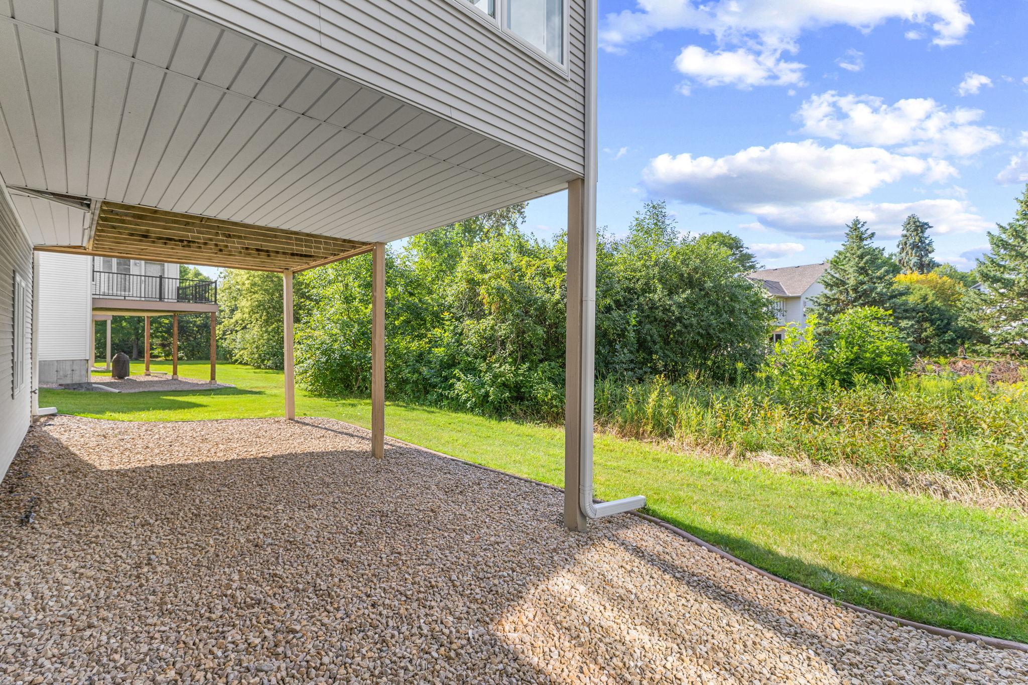 Covered outdoor space beneath the deck overlooks the surrounding greenery.